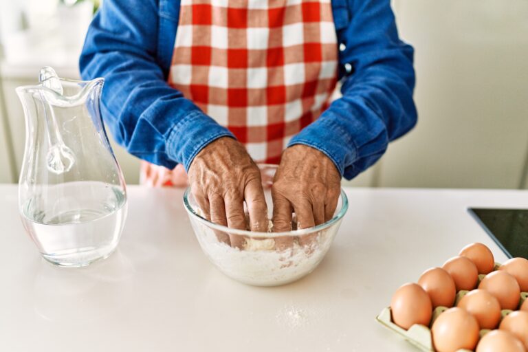 hombre mayor cocinando en casa